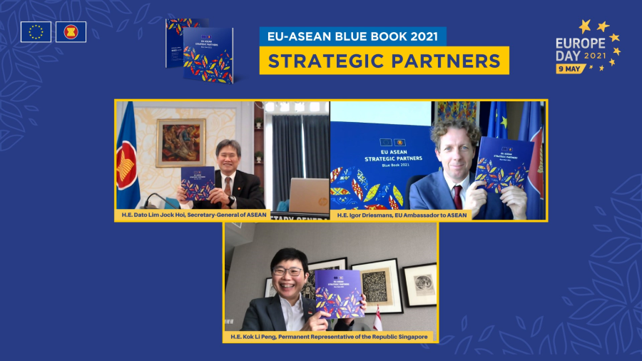 Three people on video calls holding the EU-ASEAN Blue Book 2021, against a blue backdrop.